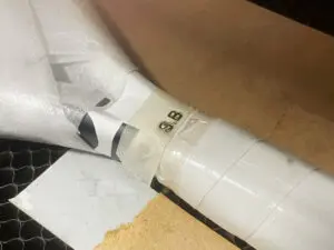 Détail de la gravure laser des initiales sur le manche d'une raquette de tennis après fabrication d'un gabarit de positionnement